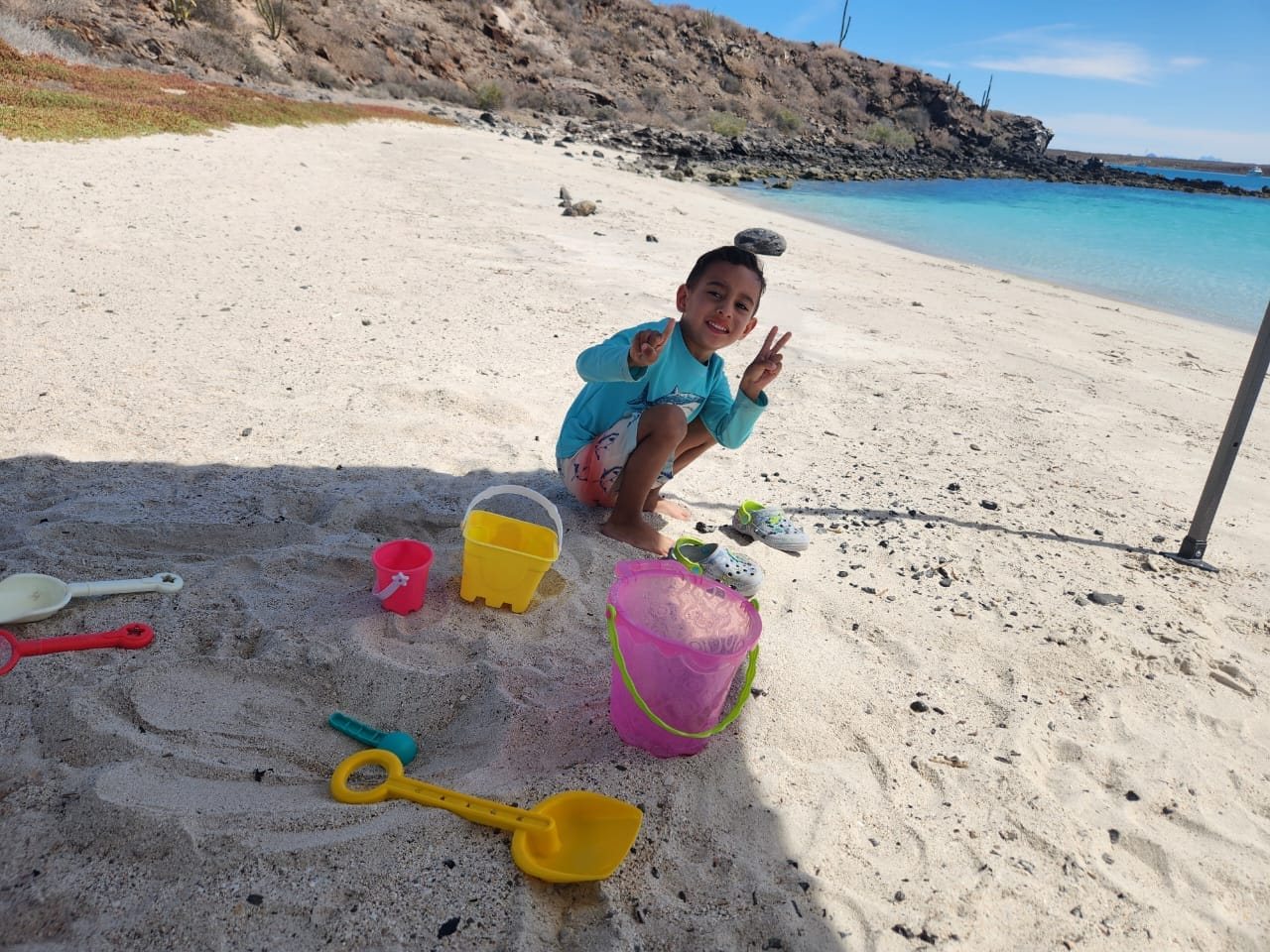 Un niño jugando en la playa de arena blanca de Isla Coronado, Loreto